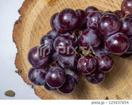 Grapes kishmish on a wooden background. The grapes are overripe. Harvest in the village. 125637854