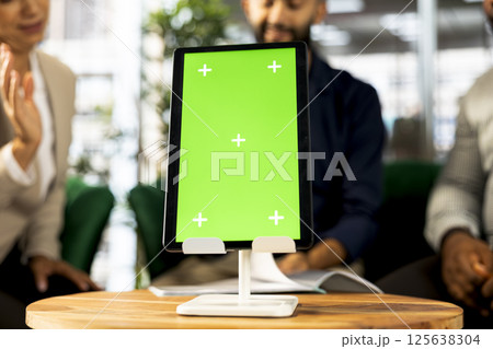 Focus on isolated screen tablet used by employees in blurry background preparing for business meeting. Close up of chroma key device used by people doing research analysis for startup organization 125638304