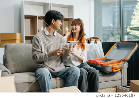 Asian young attractive couple man and woman use tablet and smartphone online shopping furniture decorate house Asian young attractive couple man and woman use tablet and smartphone online shopping furniture decorate house 125640187