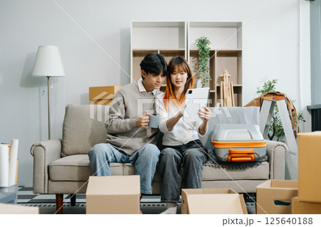 Asian young attractive couple man and woman use tablet and smartphone online shopping furniture decorate house Asian young attractive couple man and woman use tablet and smartphone online shopping furniture decorate house 125640188