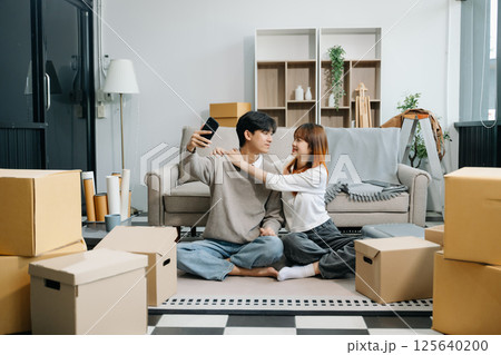 Asian young attractive couple man and woman use tablet and smartphone online shopping furniture decorate house  125640200