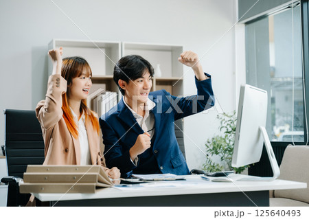 Two Asian businesswoman and man discuss investment project working and planning strategy Two Asian businesswoman and man discuss investment project working and planning strategy 125640493