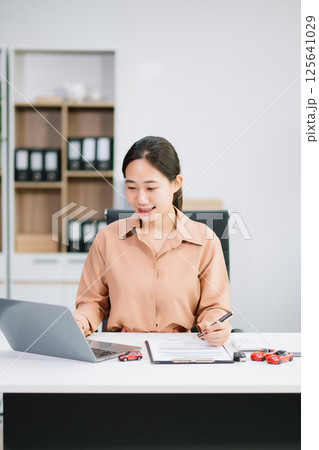 Asian people car salesman or sales manager offers to sell a car and explains of signing a car contract and signing car 125641029