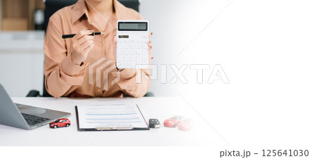 Asian people car salesman or sales manager offers to sell a car and explains of signing a car contract and signing car 125641030