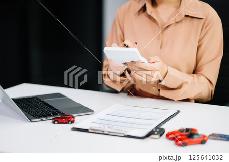 Asian people car salesman or sales manager offers to sell a car and explains of signing a car contract and signing car Asian people car salesman or sales manager offers to sell a car and explains of signing a car contract and signing car 125641032