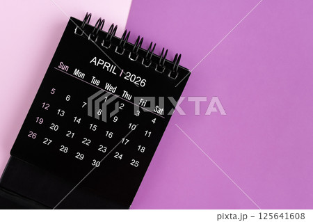 April black desk calendar for 2026 year on purple background. 125641608