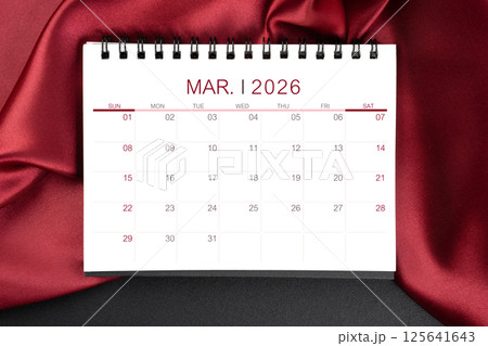March 2026 Monthly desk calendar with red silk on black leather background. 125641643