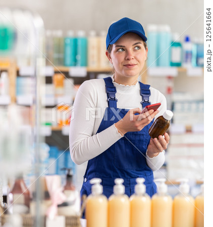 Young woman worker scanning qr code of syrup 125641664