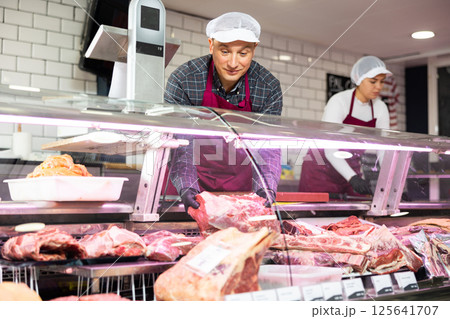 Young male butcher showing big piece of beef meat in butchery 125641707