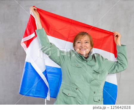 Cheerful senior woman standing confidently with dutch flag Cheerful senior woman standing confidently with dutch flag 125642028