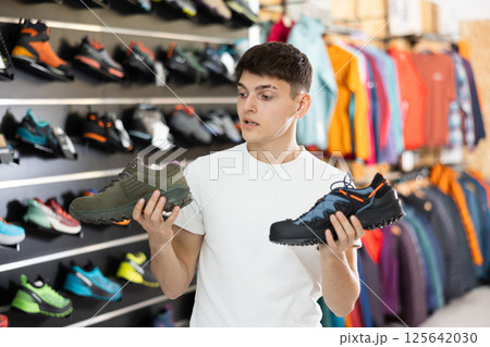 Guy choose summer shoes for hiking 125642030