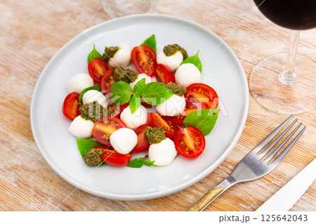 Traditional snack of Italian cuisine is Caprese with basil and Pesto sauce Traditional snack of Italian cuisine is Caprese with basil and Pesto sauce 125642043