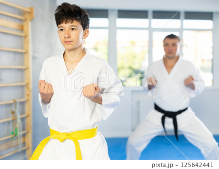 Man and boy teenager train karate technique Man and boy teenager train karate technique 125642441