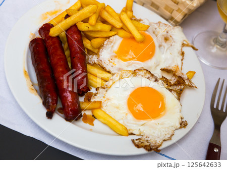 Huevos con chistorra. Scrambled eggs with sausage and potatoes. Huevos con chistorra. Scrambled eggs with sausage and potatoes. 125642633