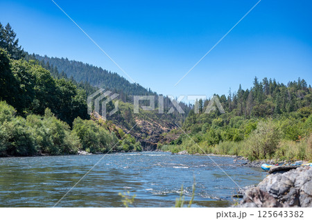 Wild and scenic Rogue River in Southern Oregon with a distant rafter floating. Wild and scenic Rogue River in Southern Oregon with a distant rafter floating. 125643382