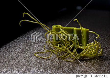 spaghetti failure on a 3D printer caused by high temperatures turning filament into a fluid state. 125643419