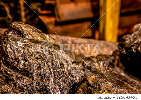 Selective focus on anthracite coal on a conveyer belt with defocused group in the Lackawanna Coal Mine Tour at McDade Park. Selective focus on anthracite coal on a conveyer belt with defocused group in the Lackawanna Coal Mine Tour at McDade Park. 125643465