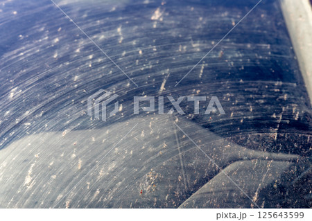 Smeared and dirty front windshield of a vehicle after hitting bugs. Smeared and dirty front windshield of a vehicle after hitting bugs. 125643599