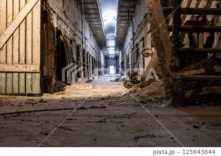 Ground level view of the dirty floor down a cell block at Eastern State Penitentiary historic site. 125643644