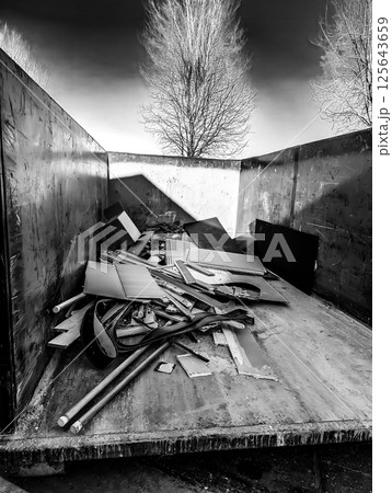 View inside an open dumpster being filled with construction debris.  125643659