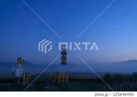 朝霧立ち込める踏切が越美北線の始発列車を待っている 125646499