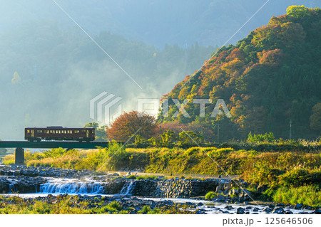 朝日に輝く紅葉と若桜鉄道の気動車 125646506
