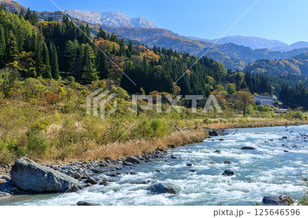 水流豊かな姫川のそばから紅葉の長野県小谷村の朝の風景と大糸線を望む 125646596
