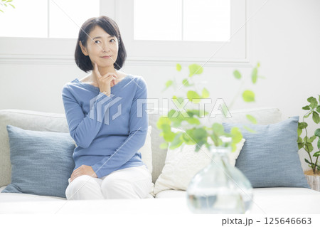 リビングで悩むミドル女性 125646663