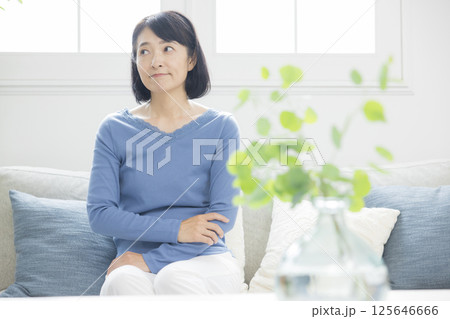 リビングで悩むミドル女性 125646666