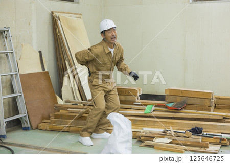 腰痛の解体作業現場で働く作業員 腰痛の解体作業現場で働く作業員 125646725