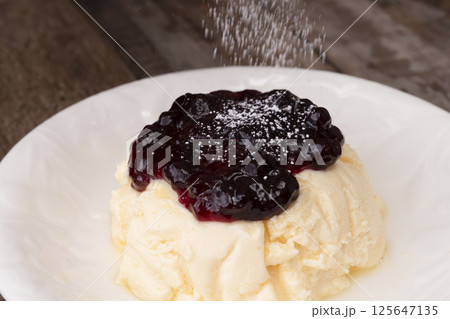 高タンパクなギリシャヨーグルトを使ったケーキにブルーベリーソースをかけて仕上げる 125647135