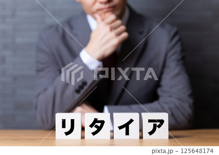 リタイアのブロックとスーツを着て悩むミドル男性ビジネスマン 125648174