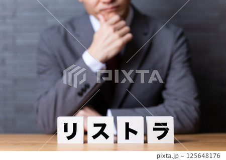 リストラのブロックとスーツを着て悩むミドル男性ビジネスマン 125648176
