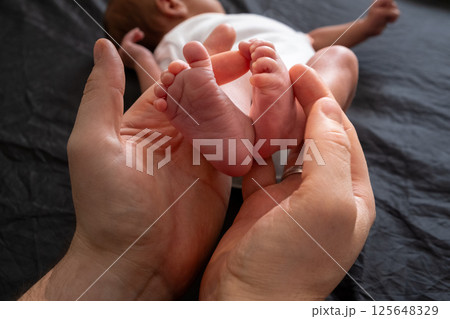 Tender Moment: Holding Newborn Baby Feet 125648329