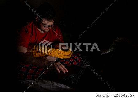 Father Holding Baby While Using Laptop in Dim Light Father Holding Baby While Using Laptop in Dim Light 125648357