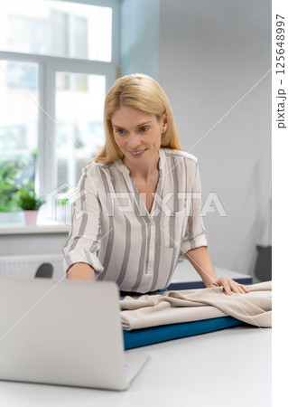 Fashion designer conducting an online workshop in her studio 125648997