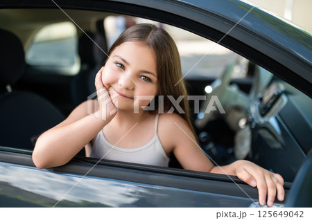 Child traveling as passenger in automobile on her way to school 125649042