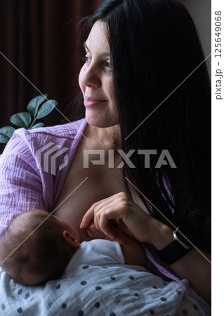 Mother Breastfeeding Baby by Window 125649068