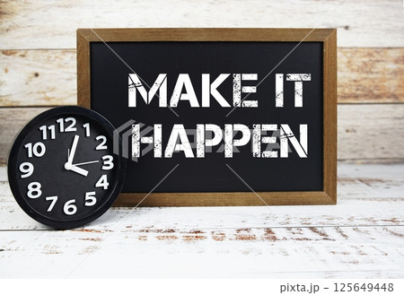 Make It Happen text message and alarm clock on wooden background Make It Happen text message and alarm clock on wooden background 125649448