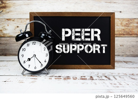 Peer Support text message and alarm clock on wooden background 125649560