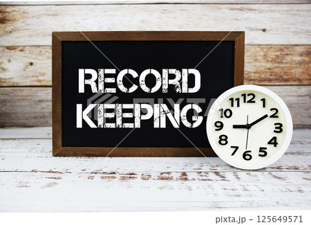 Record Keeping text message and alarm clock on wooden background 125649571