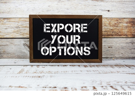 Expore Your Options text message and alarm clock on wooden background Expore Your Options text message and alarm clock on wooden background 125649615