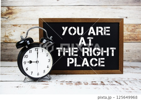 You are at The Right Place text message and alarm clock on wooden background 125649968