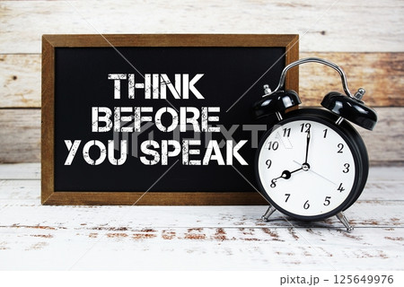 Think Before You Speak text message and alarm clock on wooden background Think Before You Speak text message and alarm clock on wooden background 125649976