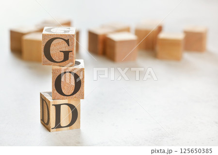 Three wooden cubes with word GOD, on white table, more in background, space for text in right down corner Three wooden cubes with word GOD, on white table, more in background, space for text in right down corner 125650385