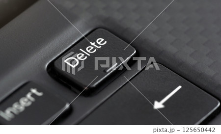 Closeup macro detail of Delete key on black laptop keyboard 125650442