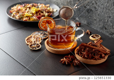 Cup of herbal tea with ingredients and slices of dried orange slices. 125651330