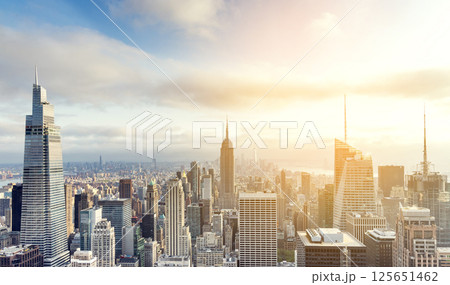 Sunset view of Manhattan skyline bathed in warm golden light and surrounded by glowing skyscrapers Sunset view of Manhattan skyline bathed in warm golden light and surrounded by glowing skyscrapers 125651462