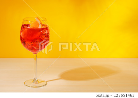 A cocktail arranged on a table against a light yellow background 125651463