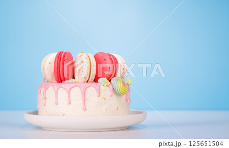 A beautifully decorated cake adorned with colorful macarons 125651504